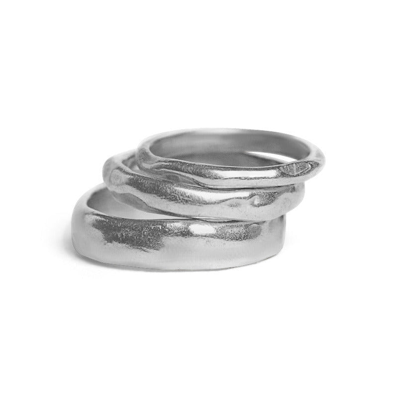 Silver ring with a wavy design on a white background