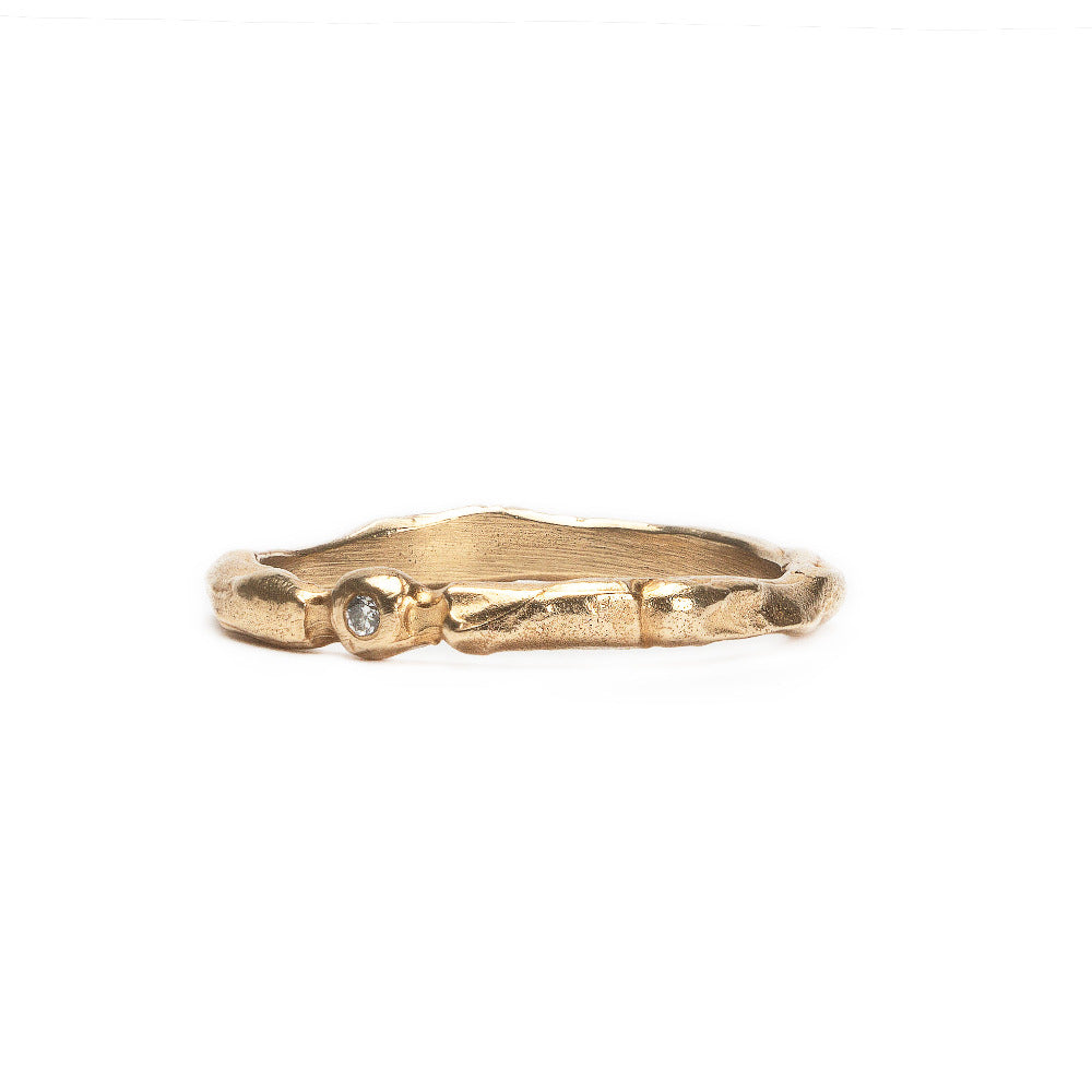 Gold ring with a small diamond on a white background