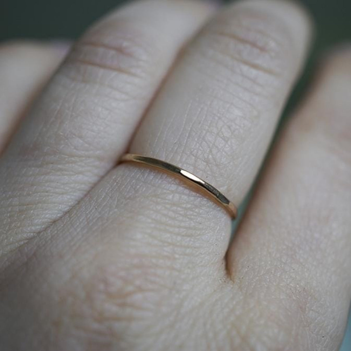 small gold ring on finger