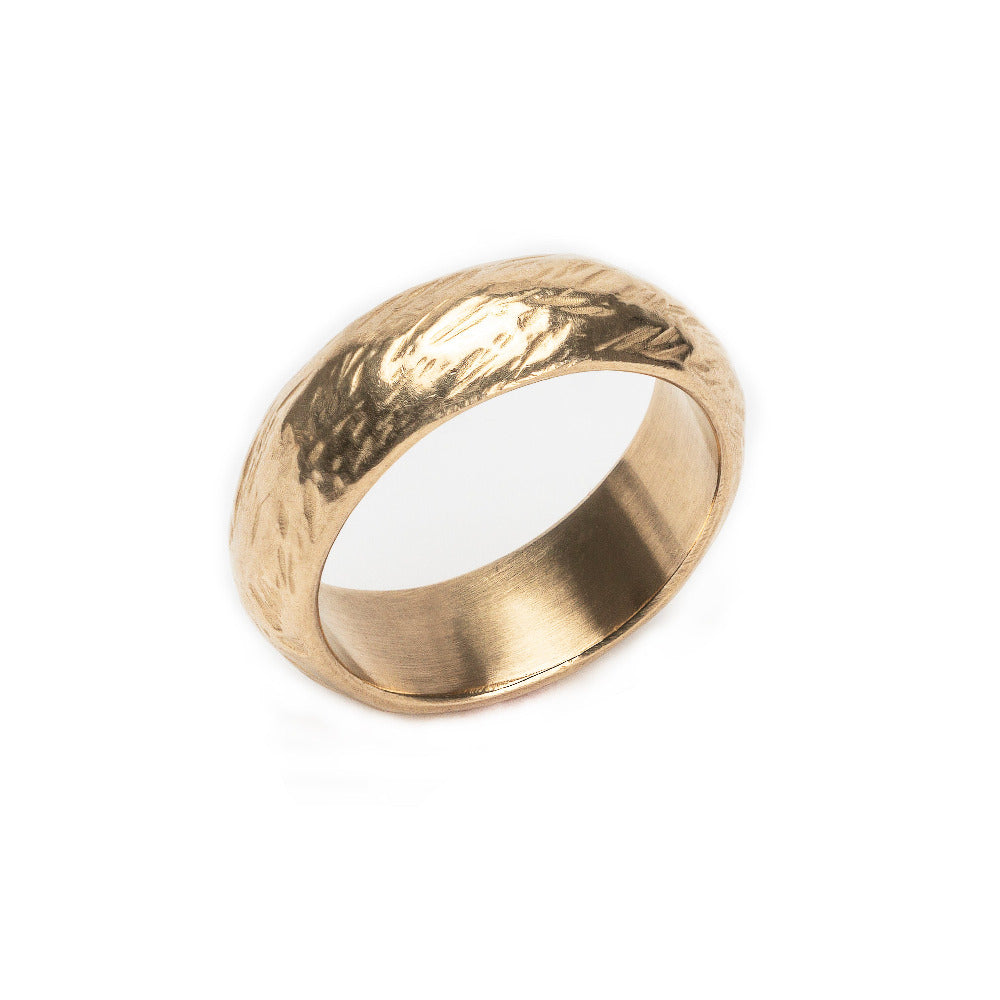Gold ring with a textured surface on a white background