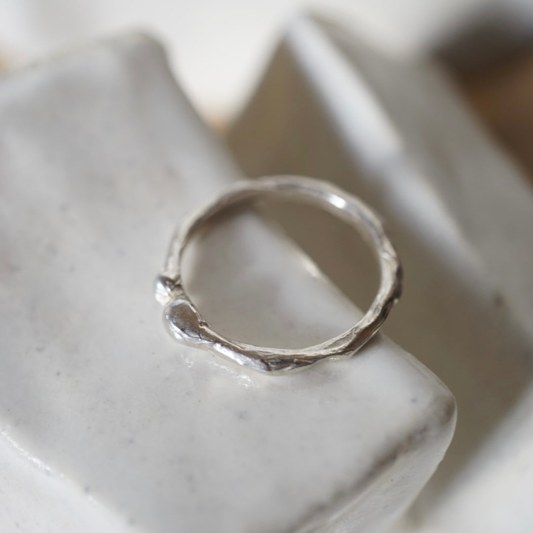 Silver ring on a textured white surface