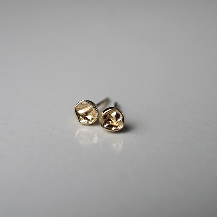 Sci fi inspired stud earrings. Small crater design made entirely of 14K yellow gold.